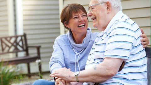 Elderly couple holding hands and laughing