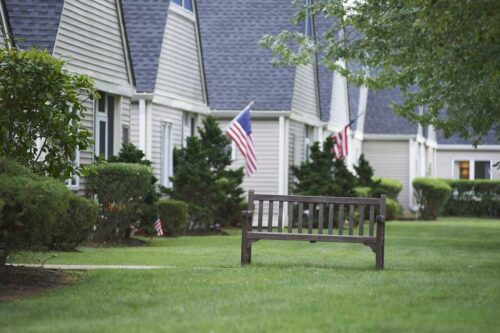 houses with bench and american flags