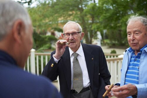 senior men talking and smoking cigars